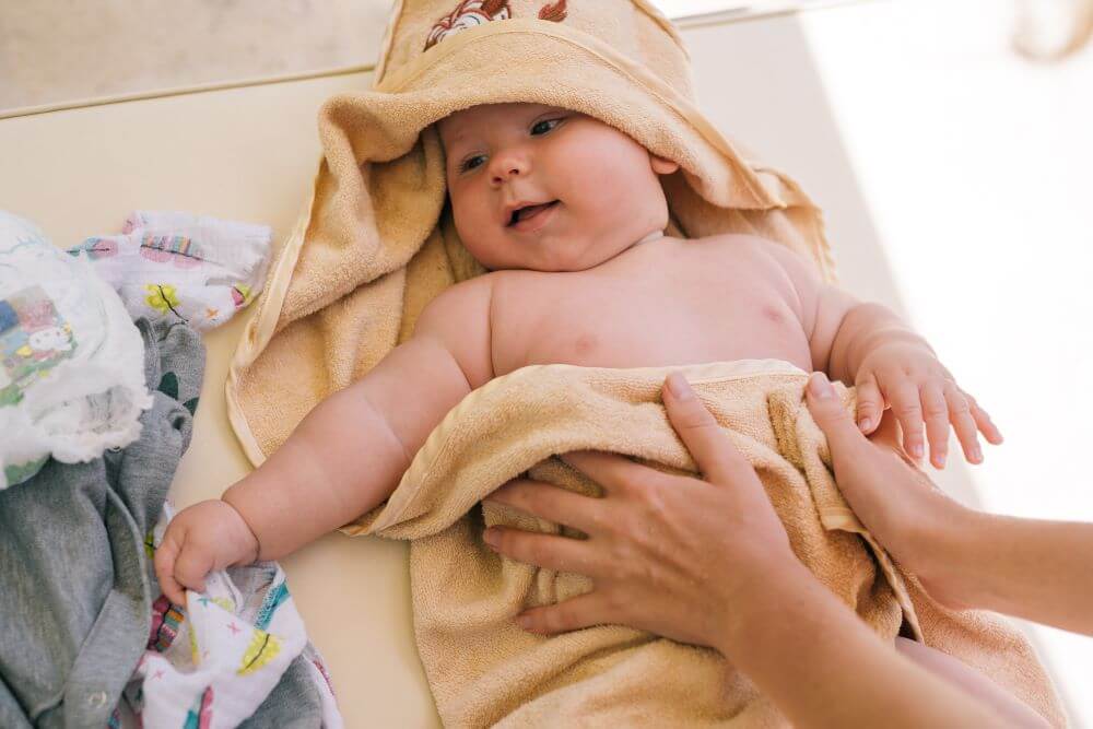 mamma asciuga neonato dopo bagnetto