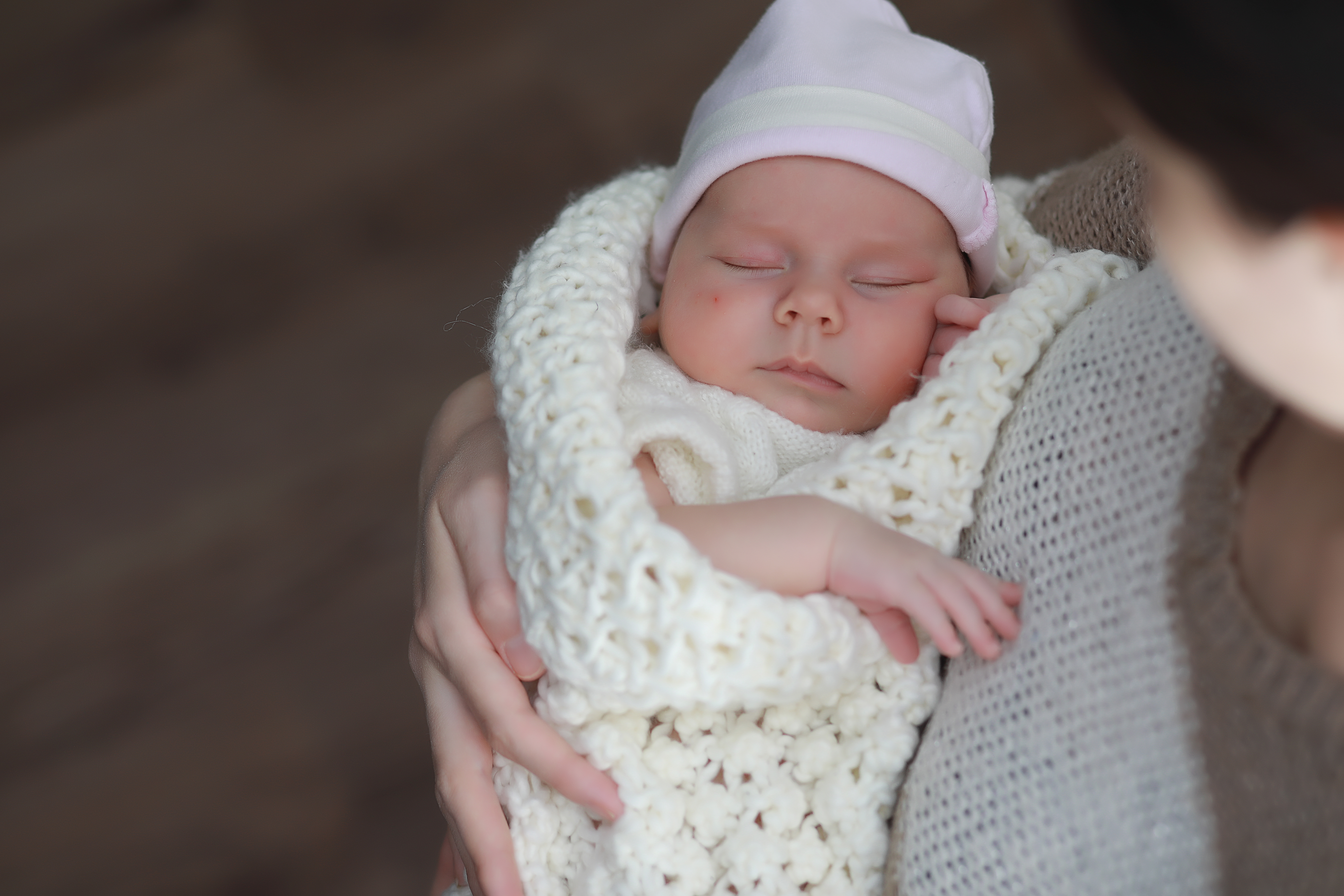 neonato avvolto da coperta tenuto in braccio