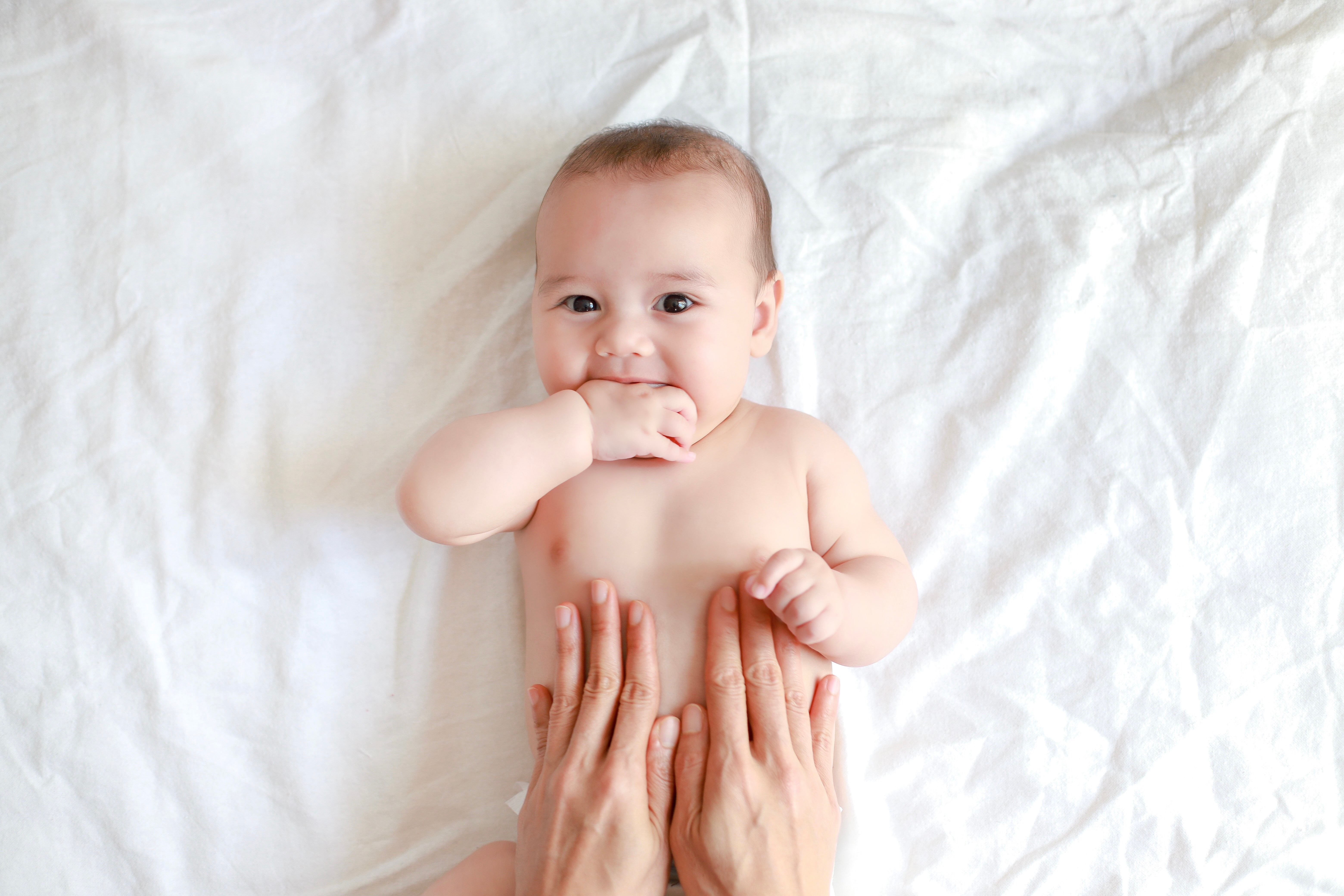 mamma massaggia pancia neonato