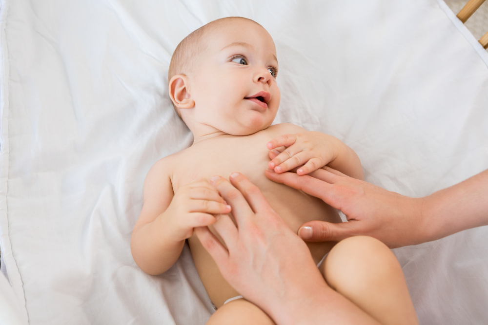 mamma massaggia pancia neonato