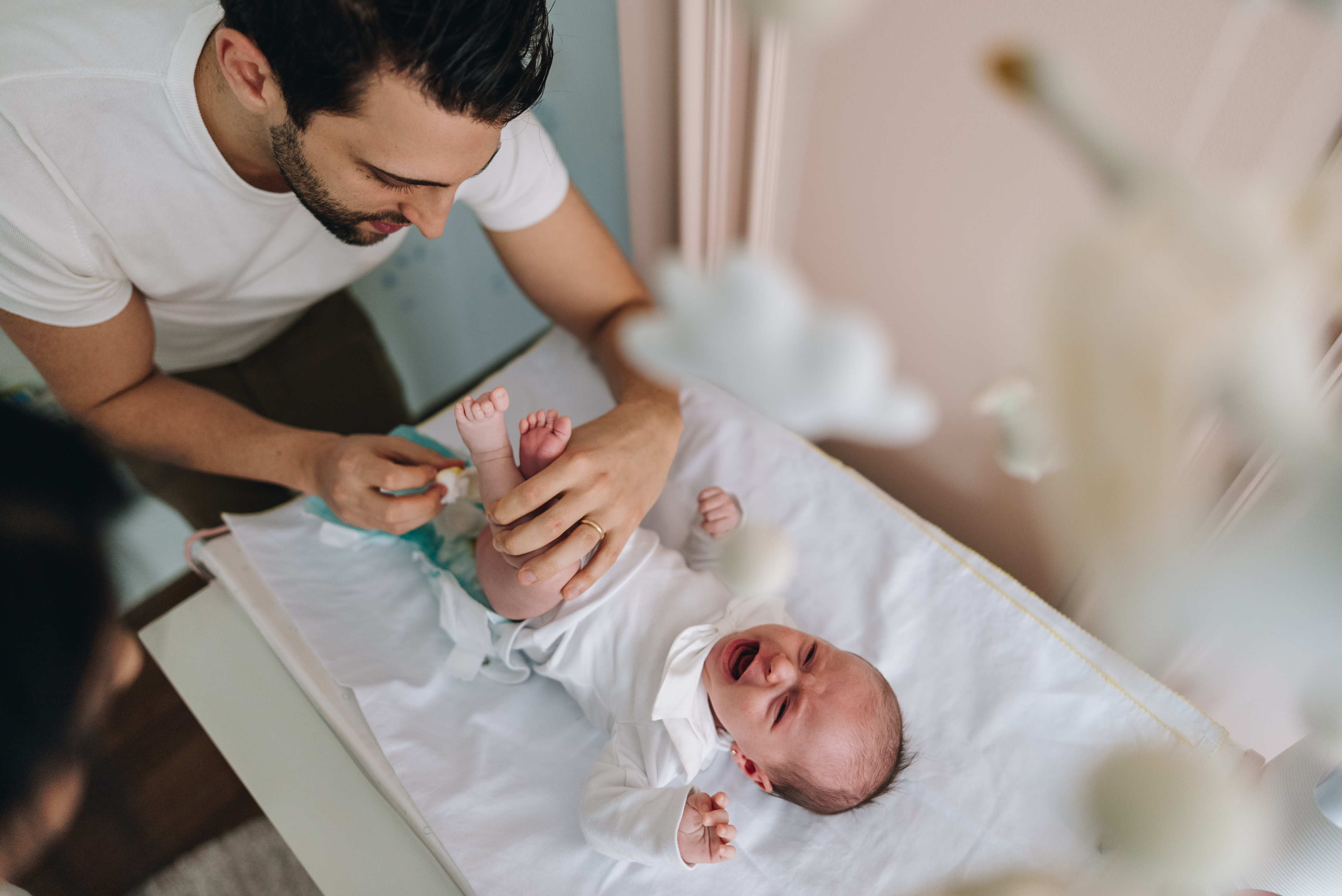 papà riveste neonato dopo cambio pannolino