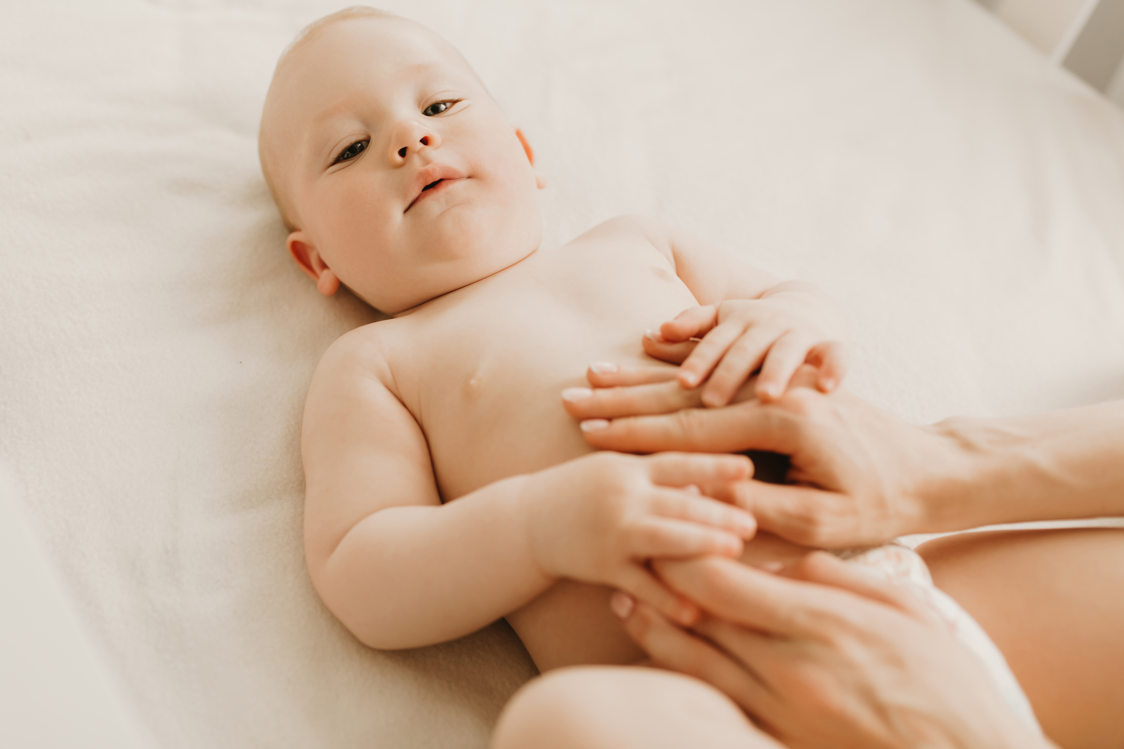 mamma massaggia pancia neonato