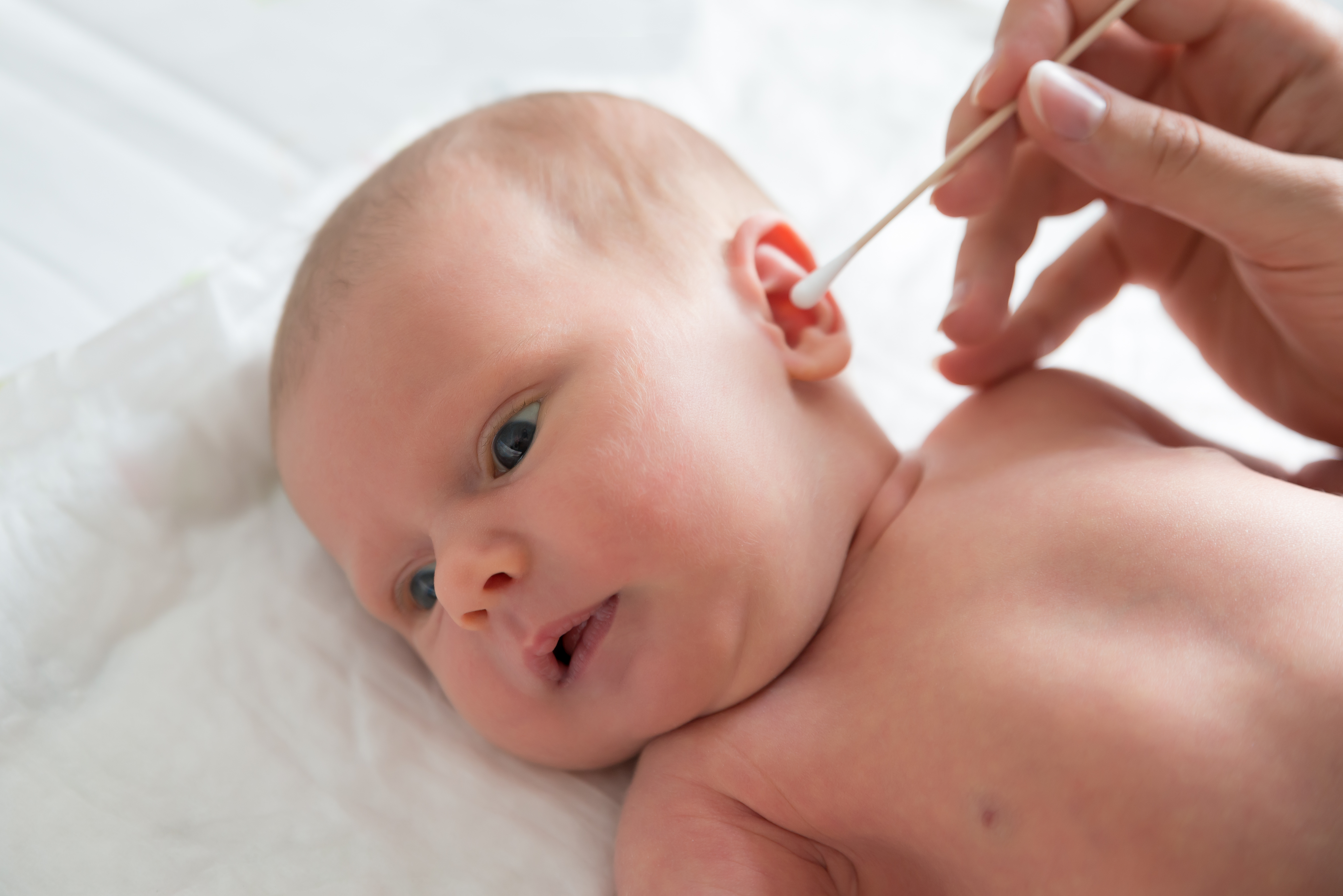 mamma che pulisce orecchie al neonato